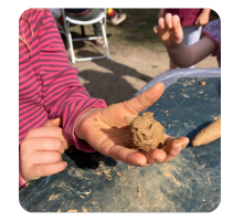 A child shows a clay animal that she has made